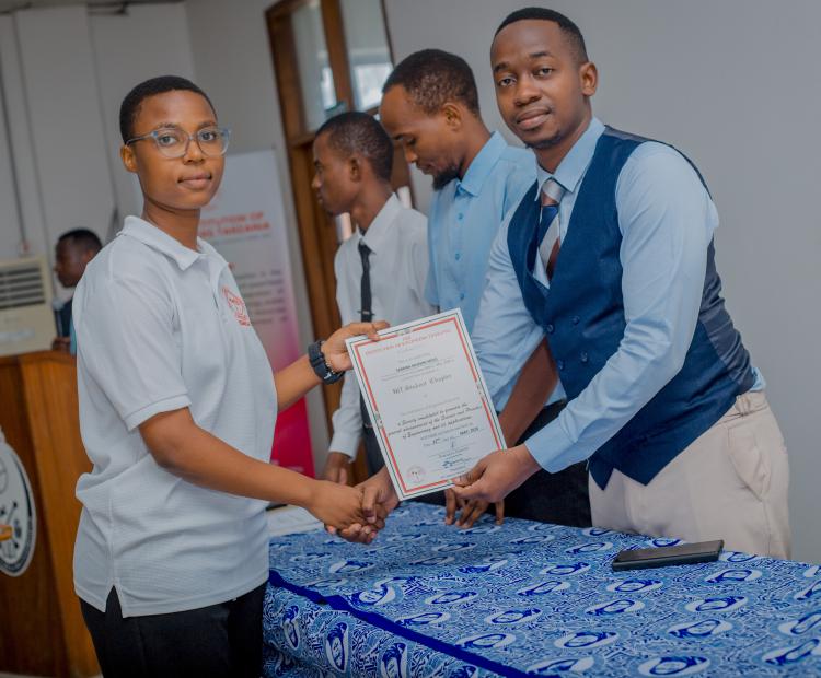 Mr. Mpoki providing certificate to IET Student leaders.